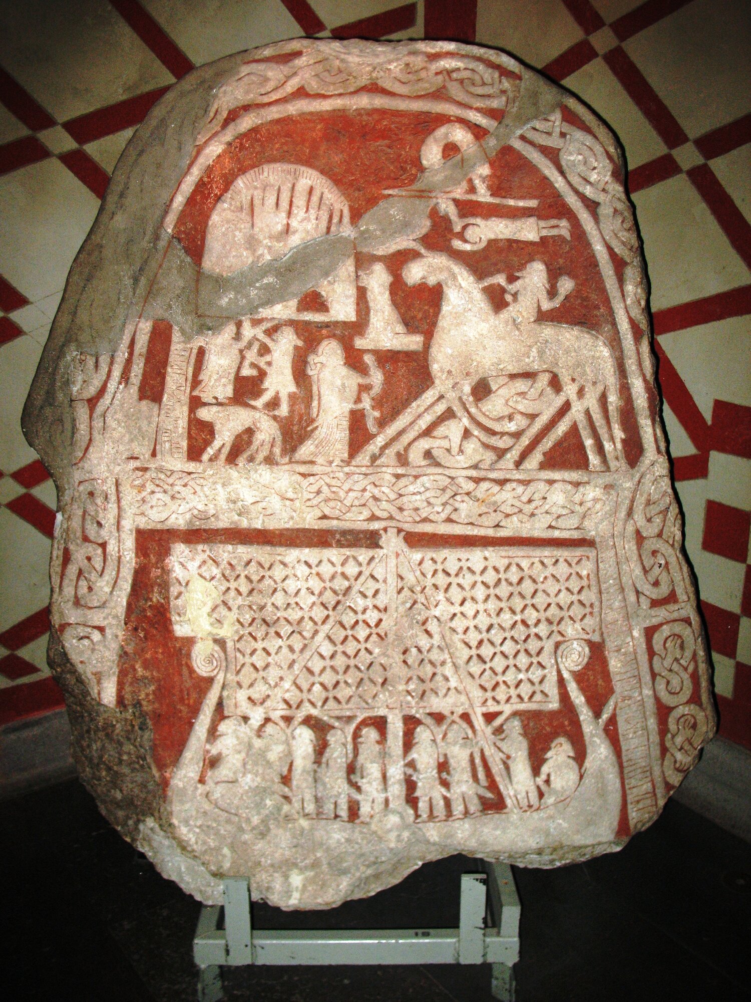 Gotländischer Bildstein von Tjängvide (G 110): das achtbeinige Pferd mit Reiter wird meist als Odin auf Sleipnir gedeutet, empfangen von einer Frau mit Trinkhorn; darunter ein Schiff mit Segel (Foto: Berig, CC BY-SA 4.0, Wikimedia Commons)