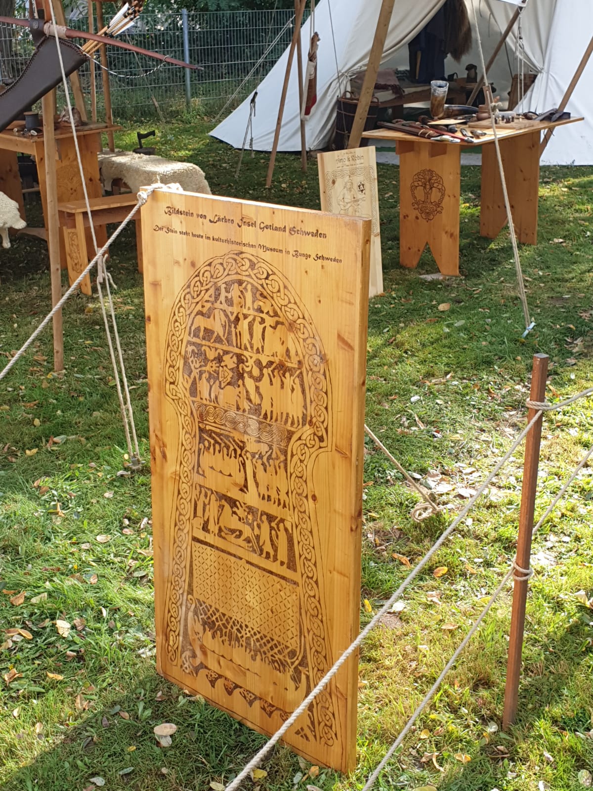 Unsere Holztafel mit Brandmalerei: Bildstein Lärbro Stora Hammars I — Figurenszenen in mehreren Registern, unten ein Schiff
