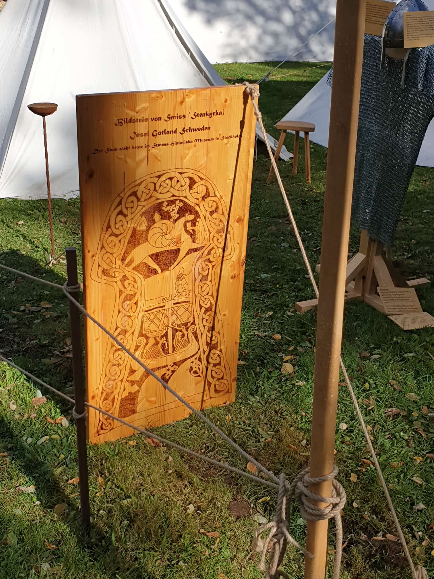 Unsere Holztafel mit Brandmalerei: Bildstein Stenkyrka Lillbjärs III — oben Reiterszene mit Wirbelscheibe, unten Schiff mit rautengemustertem Segel (Tafel-Beschriftung nennt irrtümlich „Smiss")
