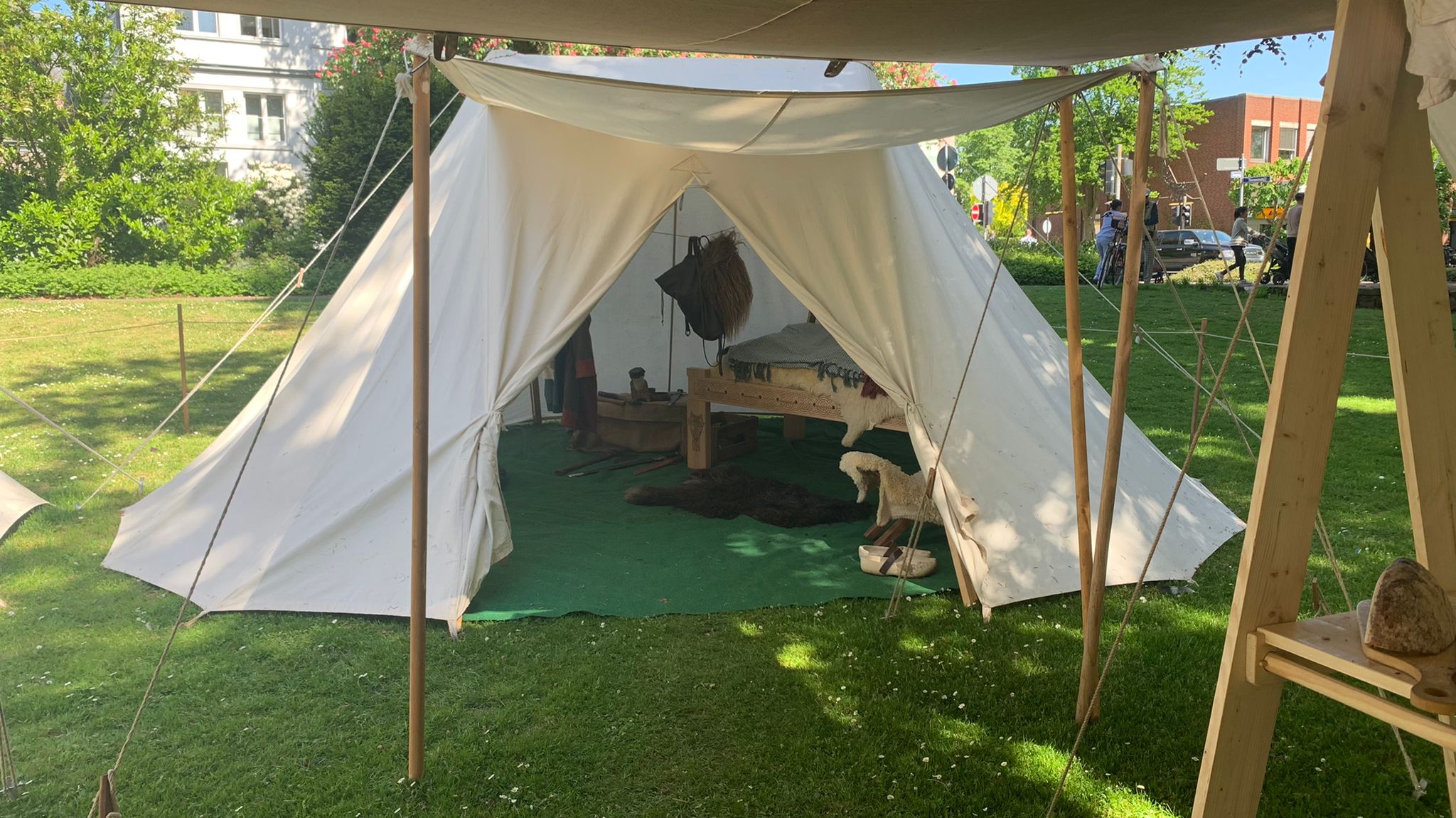 Blick ins offene Schlafzelt: Bett mit Fellen auf dem Holzgestell