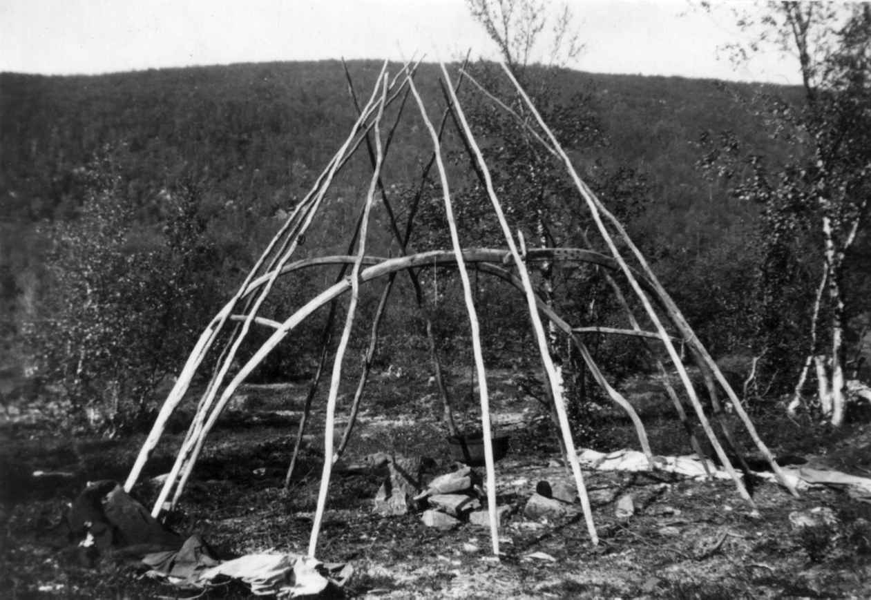 Gerüst einer mobilen Goahti beim dokumentierten Aufbau in Sirma 1933. Die zwei gebogenen Hauptrahmen, verbindende Querhölzer und ergänzende gerade Stangen sind ohne Hülle klar erkennbar. Norsk Folkemuseum, NF.05507-024; wesentlich jünger als 750–1050 und nur ethnografischer Konstruktionsvergleich. CC BY-SA 4.0.